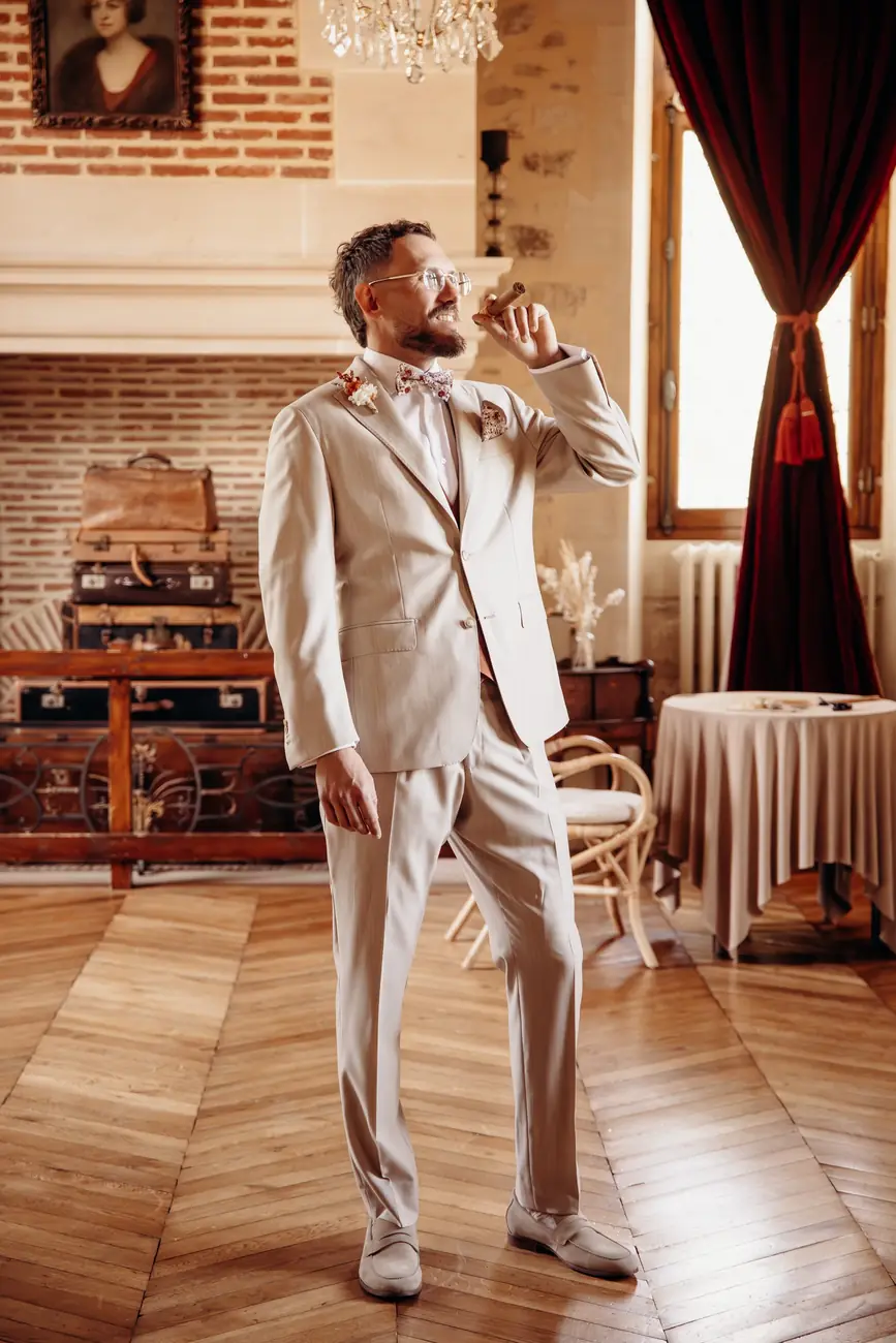 Marié en costume beige avec un cigare